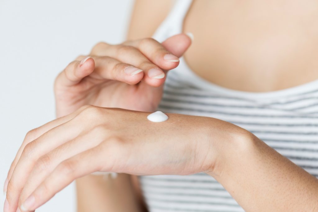 Woman Applying Lotion to Hands