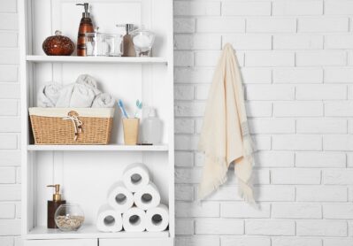 Bathroom set with towels, toothbrushes and basket on a shelf