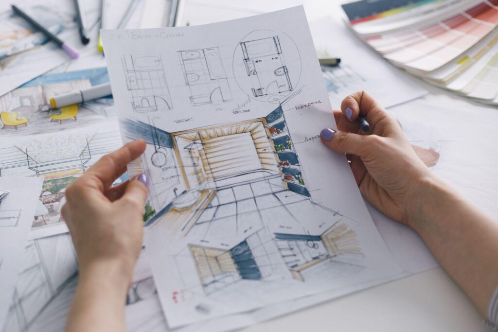 Interior designer working on color hand drawings of bathroom interior at work place