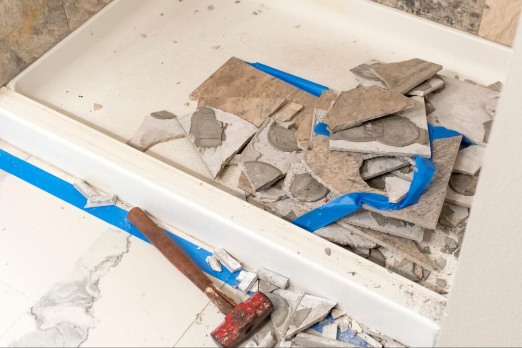 Construction and demo work during a home remodel on a tiled shower tub in a bathroom of a residential home.