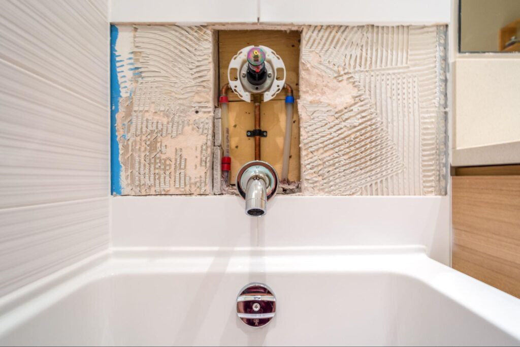 Faucet repair in the bathroom. Broken shower faucet plumbing job.